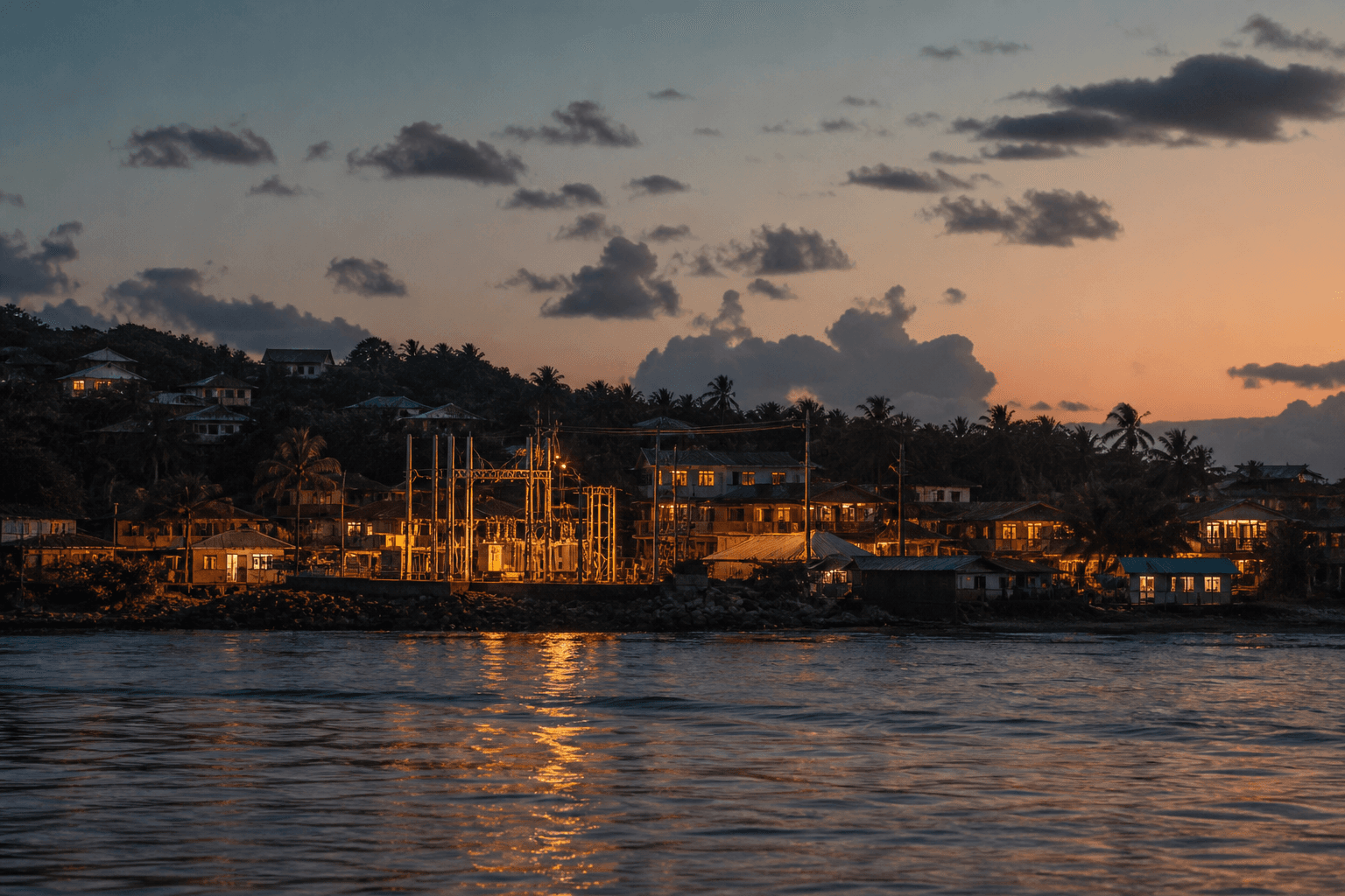 A Belize coastal town at dusk with warm lights coming on